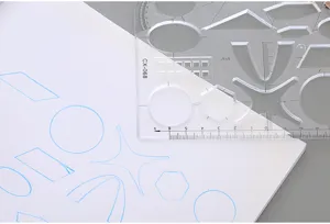 Gros plan d'une règle de géométrie transparente dessinant des formes sur papier