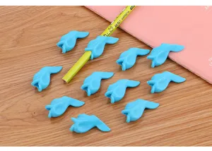 Close-up view of cute blue fish-shaped soft silicone pencil grips displayed on a wooden desk