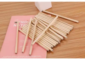 Detailed macro view of multiple natural wooden HB pencils arranged on a pink notebook cover