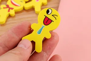 Gros plan sur une gomme jaune en forme de personnage avec un visage qui fait un clin d'œil.