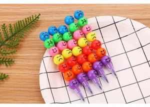 Crayons empilables colorés avec des expressions faciales sur une assiette blanche