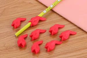 Detailed view of red fish-shaped soft rubber pencil grips for kids' writing correction