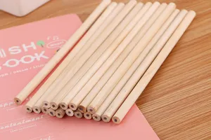 Macro view of unpainted natural wood pencils on a pink notebook for sketching