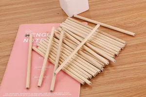 Macro view of multiple natural raw wood pencils stacked on a pink English notebook