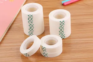Close-up of matte invisible tape rolls with green arrow patterns on a wooden desk
