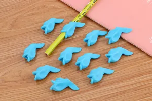 Detailed view of cute blue fish-shaped silicone pencil grips for writing correction