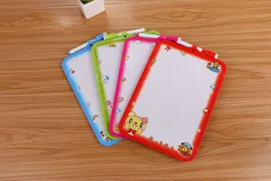 Bunte Mini-Whiteboards mit Cartoon-Motiven und Markern auf einem Holztisch