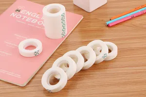 Detailed view of matte white invisible tape rolls on a wooden desk setup