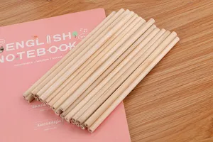 Detailed close-up of a bundle of natural unsharpened wood pencils on a pink notebook
