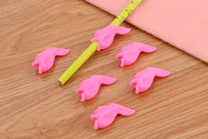 Detail of pink silicone fish-shaped pen grippers for pencil writing correction