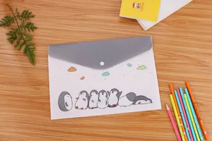 Macro di simpatiche illustrazioni di pinguini su una cartella bianca con chiusura a bottone.
