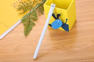Close-up of a cute cartoon cat head gel pen with a white body placed on a wooden desk surface