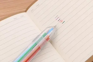 Detailansicht eines transparenten 6-Farben-Kugelschreibers mit Tintenstrichen