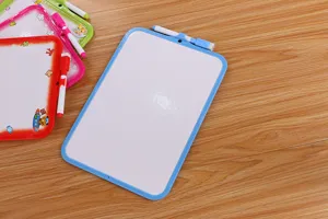 Nahaufnahme von Mini-Whiteboards für Kinder mit passenden Markern auf einem Holztisch