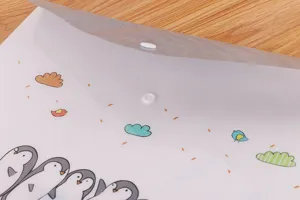 Dettaglio della borsa porta documenti con pinguini cartoon e chiusura a scatto bianco