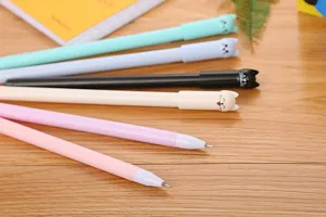 Detail of cute cat shaped pen caps on colorful gel pens for school and office use.