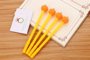 Vue détaillée de quatre stylos gel mignons en forme de citrouille sur un carnet vintage