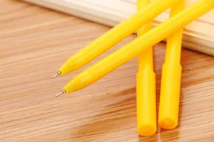 Vue macro détaillée de stylos gel jaunes à pointe fine sur un bureau en bois naturel