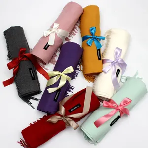 Nahaufnahme von bunten Fransenschals, die als Geschenk mit Bändern gebunden sind