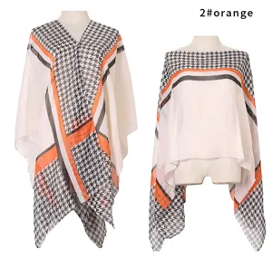 Detail view of an orange and black houndstooth sun protection shawl on mannequins