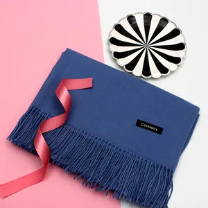 Detailaufnahme eines blauen Winterschals mit eleganten Fransen und Cashmere-Label