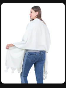 Rückansicht eines weißen Strickschals mit Bommelquasten an einem weiblichen Model