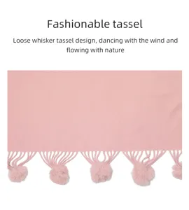 Nahaufnahme eines rosa Strickschals mit weichen Fellbommeln und elegantem Webmuster.