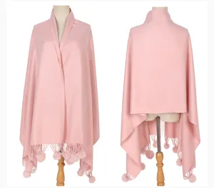 Vorder- und Rückansicht eines eleganten rosa Strickschals mit Pelzpompons am Modell