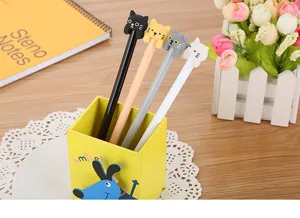 Close-up of four cute cartoon cat head gel pens in a yellow desk organizer box