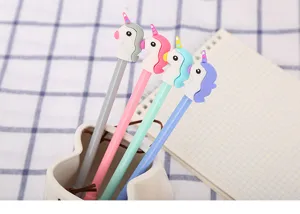 Vue détaillée de quatre stylos gel licorne colorés dans un porte-stylo en céramique