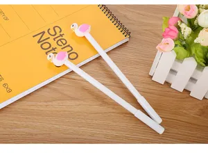 Gros plan de stylos décoratifs flamants roses sur un carnet jaune