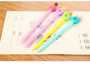 Detailed macro view of cute cartoon donut and bear gel pens on a school notebook page.