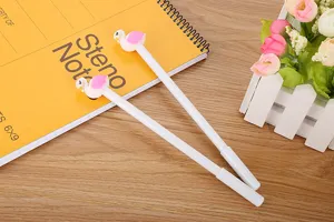 Gros plan de stylos gel mignons flamants et cygnes sur un carnet de notes jaune