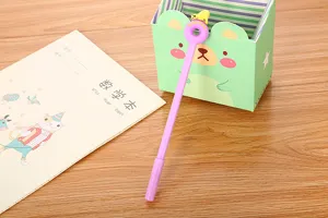 Close-up of purple gel pen with polar bear donut topper and stationery props