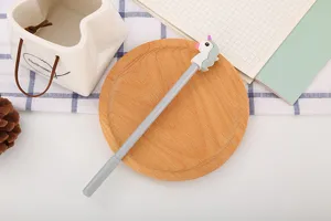 Vue rapprochée d'un stylo gel licorne gris sur un plateau en bois avec décorations
