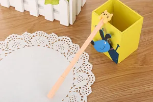Close-up of a cute cat gel pen on a wooden desk with stationery accessories