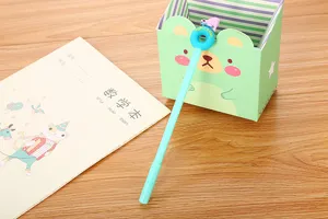Cute light blue gel pen with cartoon polar bear donut topper shown in a cozy study setting