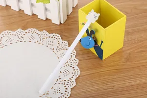 Close-up macro view of a cute white cat gel pen resting on a bright yellow holder
