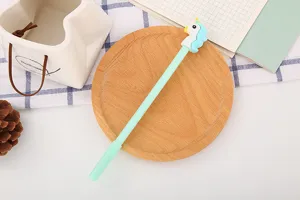 Détail d'un stylo gel licorne mignon avec corps bleu clair et décor sur plateau en bois
