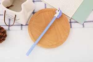Gros plan détaillé d'un joli stylo gel licorne avec un corps bleu pastel sur bois