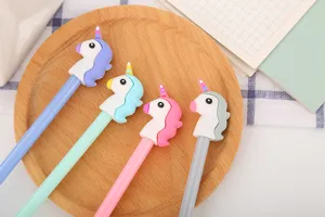 Gros plan sur des capuchons de stylos licorne colorés sur un plateau en bois naturel.
