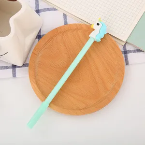 Stylo gel licorne de dessin animé vert menthe mignon placé sur un dessous de verre.