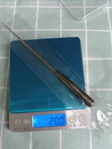 Detailed view of the stainless steel fishing hook remover being weighed on a digital scale.