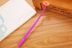 Close-up of a purple soft rubber gel pen with a cute orange flower topper on a desk