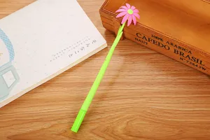 Detailed macro view of a creative pink daisy gel pen with a green stem on a desk.