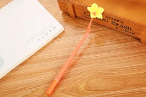 Detailed view of creative yellow flower gel pen featuring soft silicone stem on wood