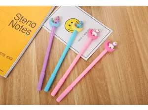 Gros plan de quatre stylos gel colorés avec des figurines de lune et de licorne sur un bureau.