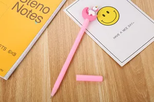 Gros plan d'un stylo gel rose mignon avec un motif lune et licorne sur un bureau