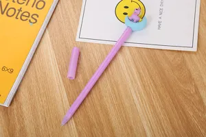 Gros plan d'un stylo gel violet avec une licorne mignonne sur une lune bleue.