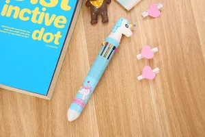 Gros plan d'un stylo bille 10 couleurs avec un capuchon licorne 3D sur un bureau